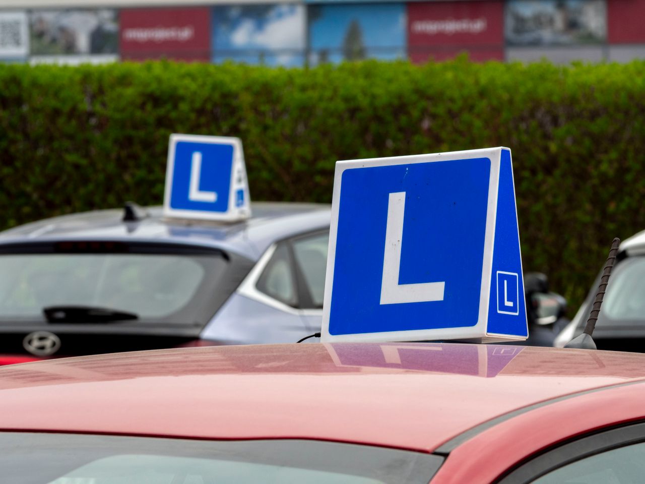 about-02 Cars with learning signs parked outdoors in Wrocław, Poland, at a driving school training area.