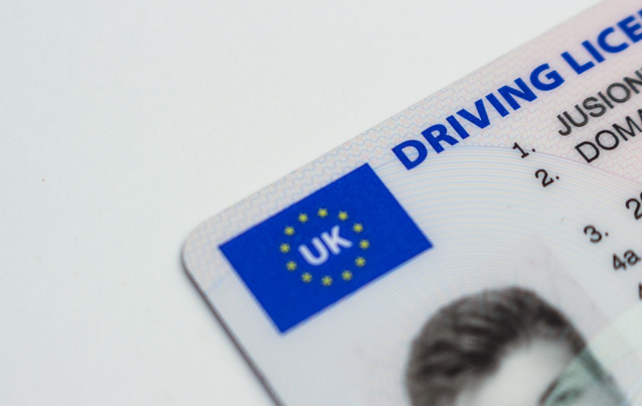 our-mission Detailed photo of a UK driving license showcasing EU flag and identity features.
