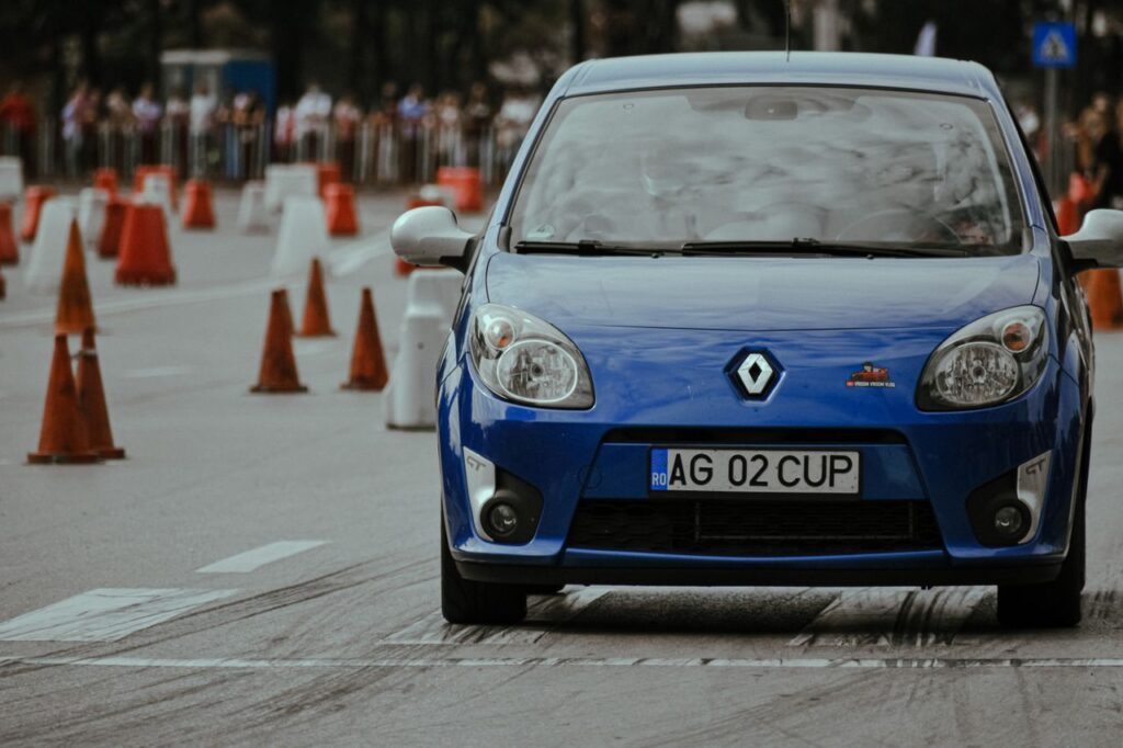 Crafting Captivating Headlines: Your awesome post title goes here Modern blue automobile with headlights riding on pavement with marking lines near traffic cones on autodrome in city street with blurred background
